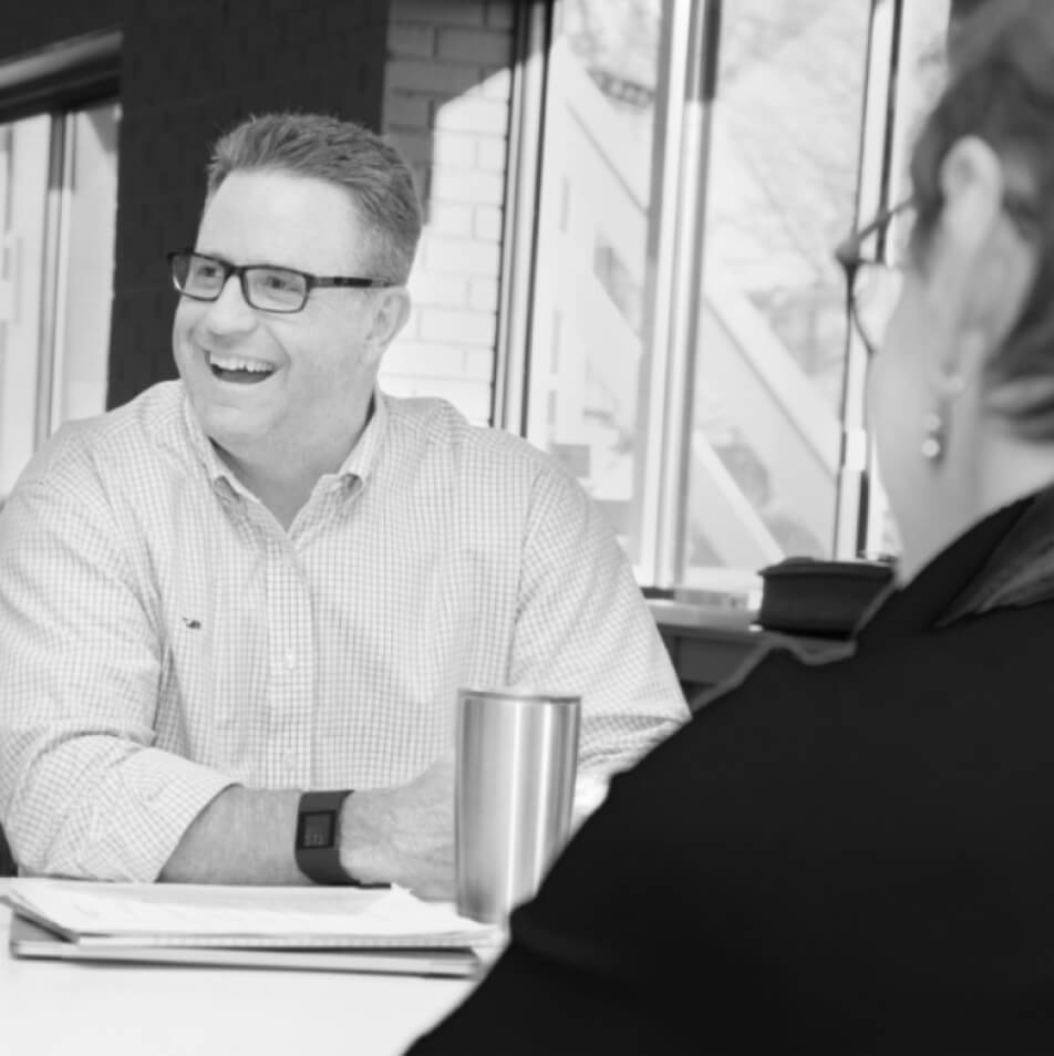 Business man smiling and looking off to the side while sitting at desk