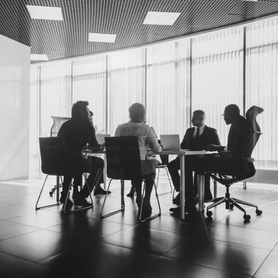 Group of business people sitting at conference table in the middle of modern office