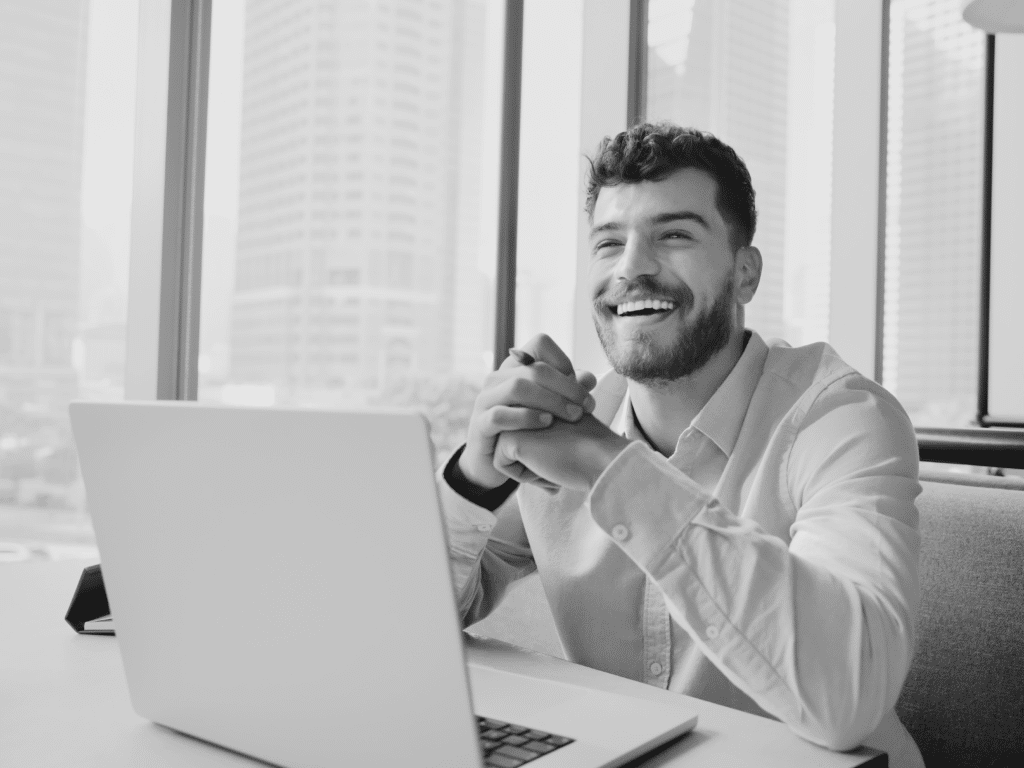 man sitting at laptop smiling